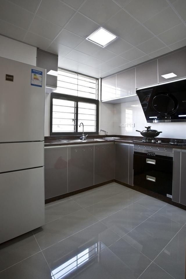 厨房也非常大,浅灰色的橱柜和地板还有集成板颜色相近,还有冰箱颜色
