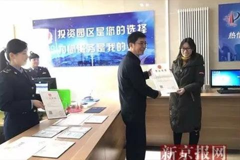 国家工商总局个体司司长熊茂平为个体户苗婷颁发首张"两证整合"个体