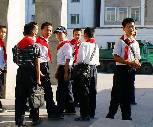 平壤街上,一群少年儿童,穿着白衬衣,戴着红领巾.