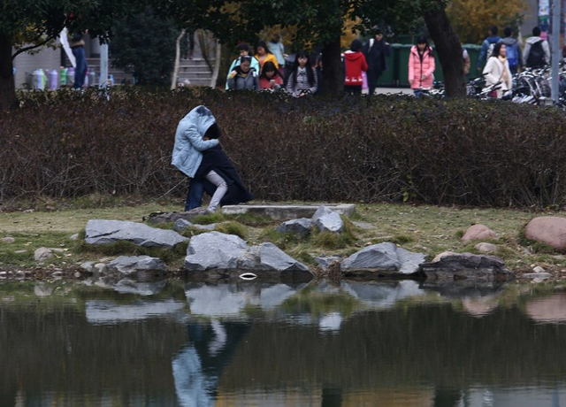 大学校园里两情侣亲热,男生主动将衣服遮盖两人,含羞的不行