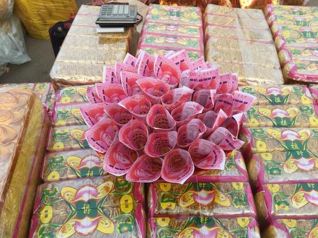 清明节冥币上市祭祀用品涌上街头 百元红钞情人花束吸