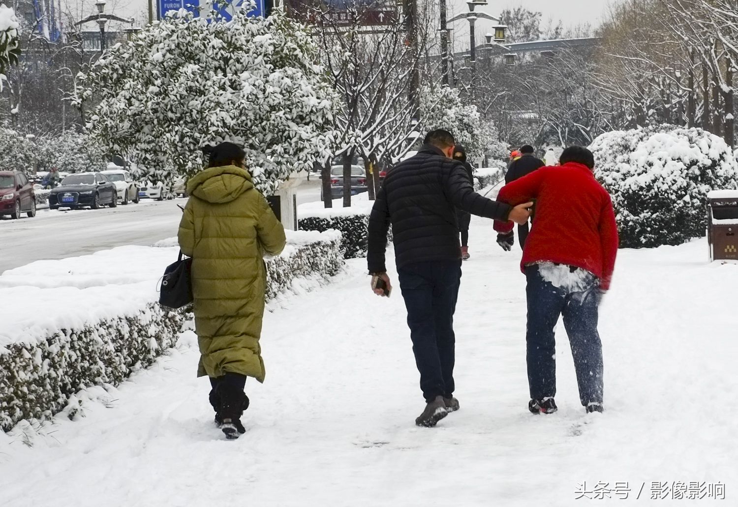 西安大妈雪地滑倒 路过男子伸手扶起她