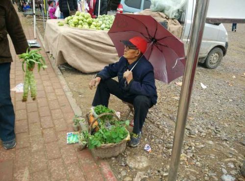 图说:集市上,各种摊位几乎都是白毛苍苍的老人守摊.