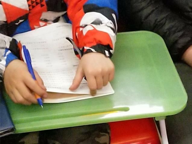 小学生自带小桌子地铁做作业,妈妈旁边辅导