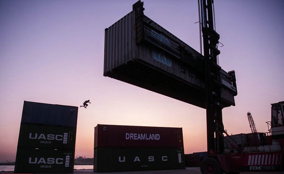 集装箱之间的大跨越，水中的倒影也完美地展现了选手的身姿。