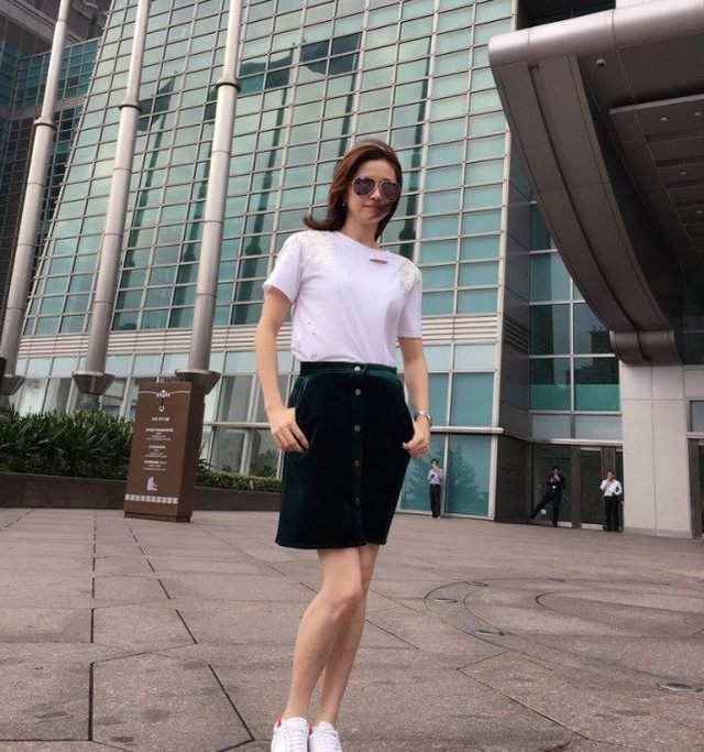 日常中的何美钿用白色t恤加半身裙做搭配,高腰的裙型强调出腰线的位