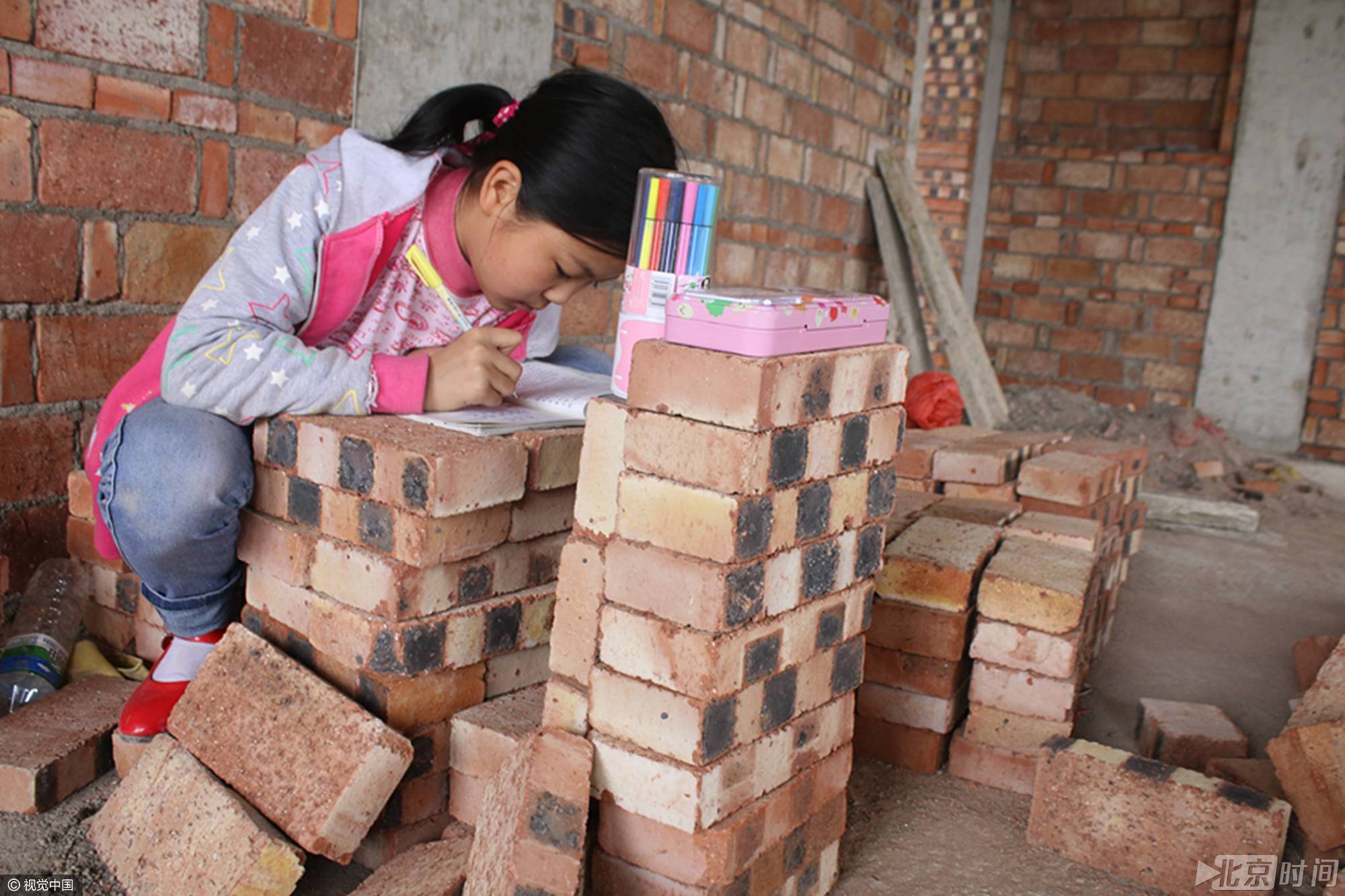父母工地盖房谋生计 11岁女孩砖块上读书