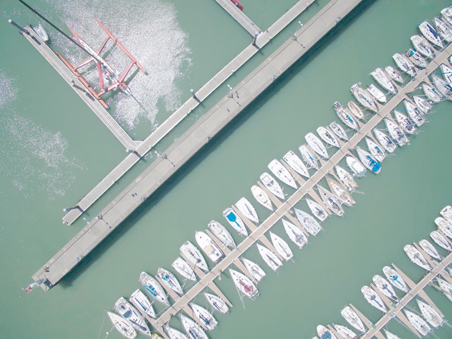 俯瞰蓝霓堤港口，这里停泊着上千艘帆船，十分壮观。而郭川的北京时间号有着数倍大于这些普通帆船的船体，颜色也是一抹醒目的亮红，在其中尤为引人注目。