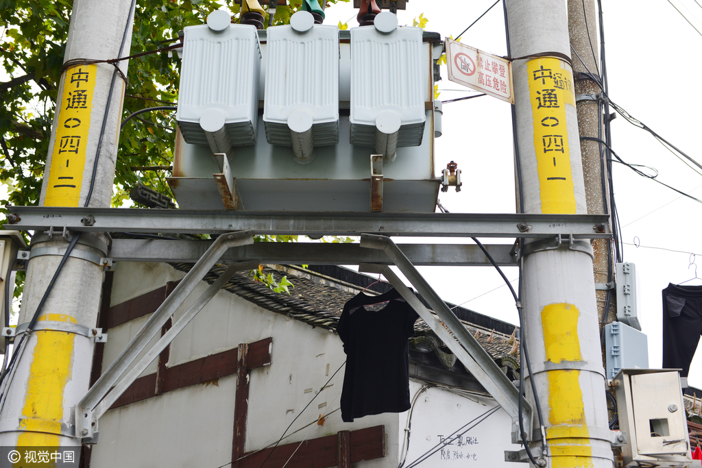 居民就把衣服挂在电线上晾晒，有的衣服直接挂在变压器下面，情况十分危险。图为居民晾晒在电线及变压器附近的衣物。