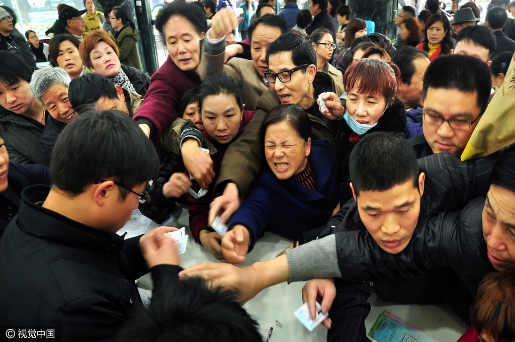 2013年03月12日，浙江省宁波市，房产交易大厅人头攒动。未提前领到二手房过户号码的群众挤向导服台，领取“实名制”号码。