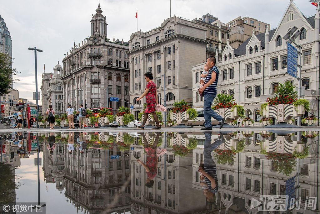 2018年7月26日，上海，当天中午上海中心气象台发布大风黄色预警，此前还发布了暴雨、雷电、高温橙色预警，截止下午2时，上海“三黄一橙”预警同时高挂。下午3时许，天空中雨势暂歇，中山东一路沿线外滩百年建筑群在积水上形成大片倒影，与天空中灰色云层相互掩映，好似一幅幅淡雅的水彩画，景色分外清丽。