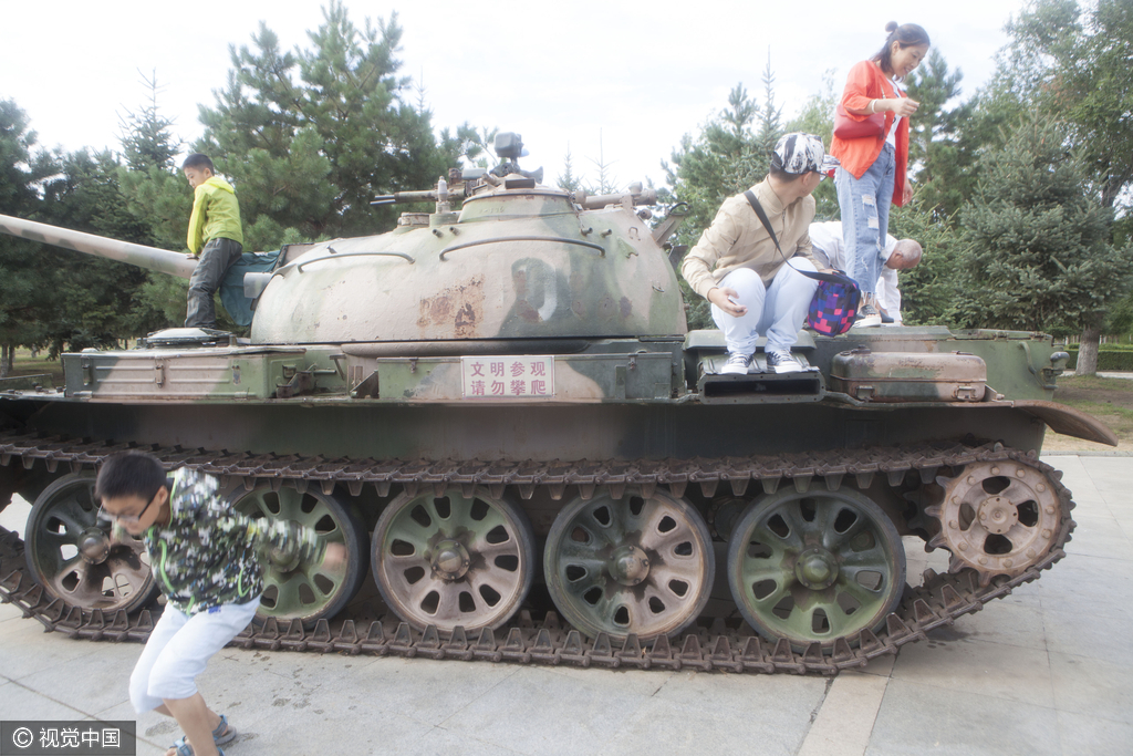 2016年08月10日，黑龙江省齐齐哈尔市，广场现坦克飞机，市民组团攀爬合影。