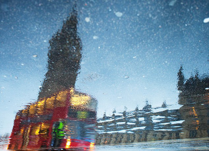 摄影师用手机巧拍水坑倒影下的城市
