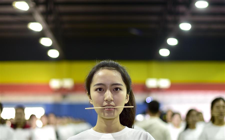 全运会美女志愿者培训 咬筷子练习微笑