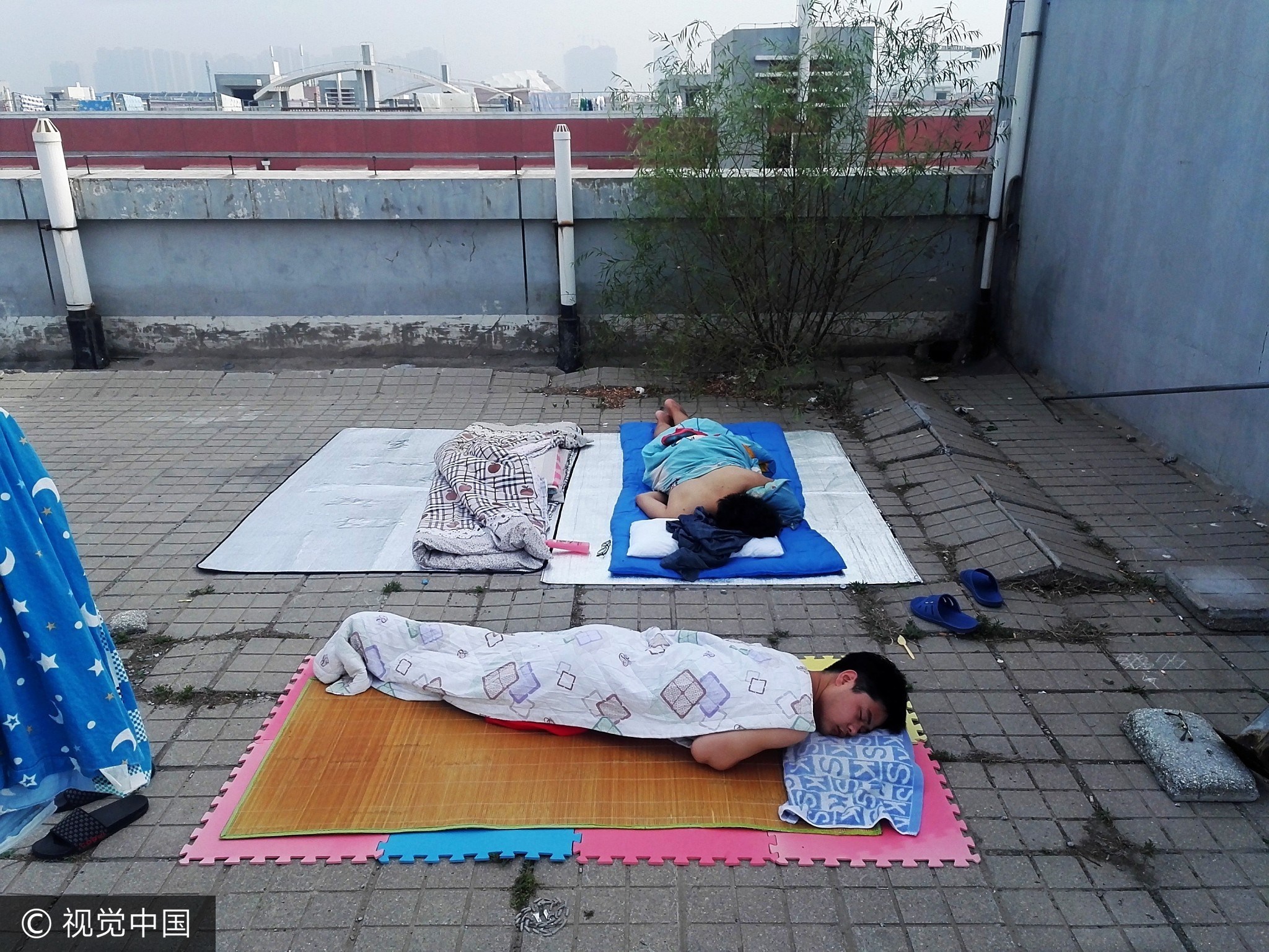 纷纷带着凉席被褥到楼顶天台打地铺过夜,还有学生在楼顶支起帐篷睡觉