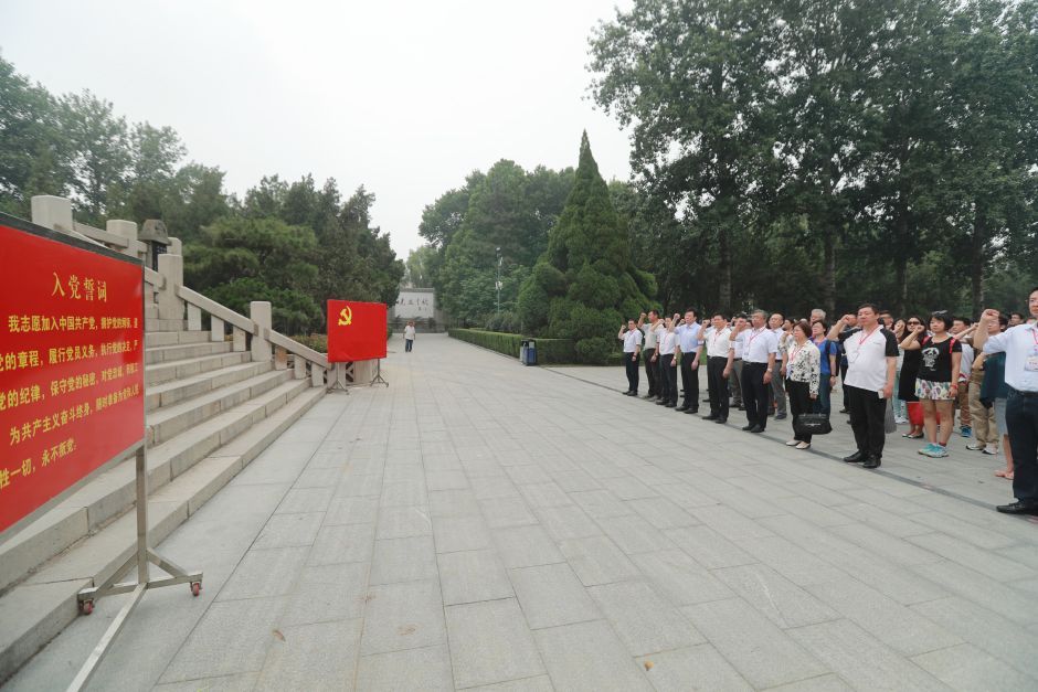 苍松翠柏,英灵安眠。6月23日上午,首都网络媒体沂蒙革命老区行代表团来到位于山东临沂的华东革命烈士陵园,举行党性教育启动仪式。图为代表团面对鲜红的中国共产党党旗,庄严举起右拳,重温入党誓词。记者 王长坤 摄