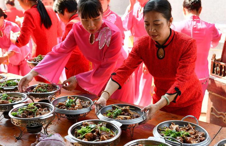 盛装的阿姨们表演完节目，就来当端菜的义工。