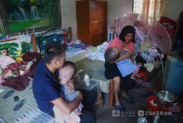 接下来的日子，孩子的头一天天变大，孩子妈妈每天看着孩子，越来越怕，不堪目视孩子痛苦，索性回到娘家。图为奶奶抱着孩子，满脸愁容。