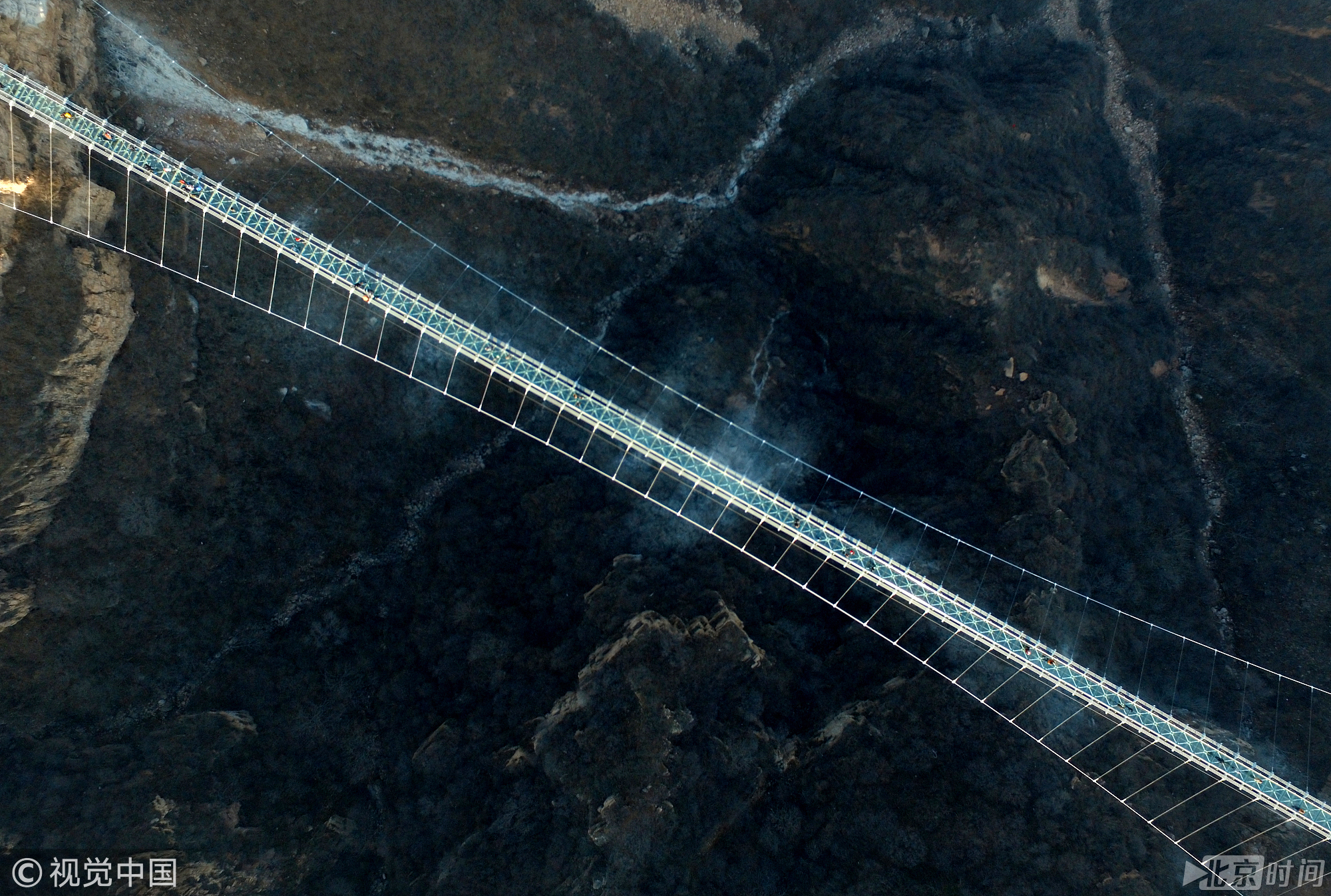 近日，位于河北省平山县红崖谷景区的悬跨式玻璃桥正式开放。该桥全长488米，宽4米，桥面与地面垂直落差约218米，可容纳600人同时通过。