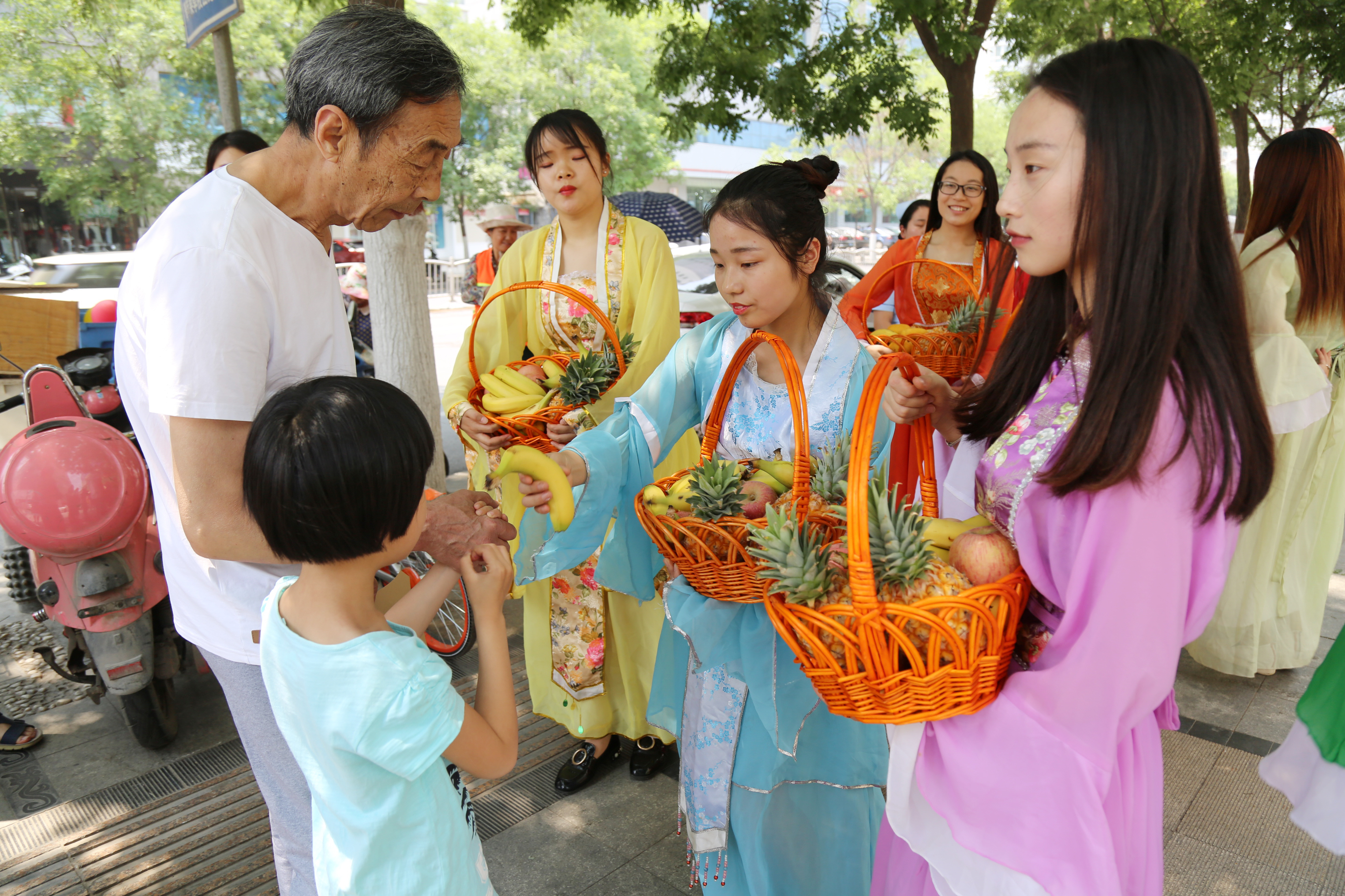 郑州百果园员工扮七仙女 街头送水果给市民降