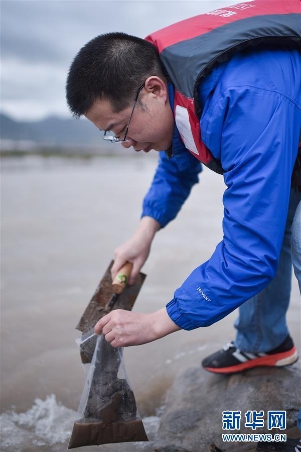 8月8日，长江科学院科考队员赵良元在聂恰曲采集泥沙样本。