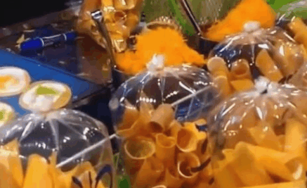 大妈在校门口卖小吃,1元一个,生意真好,手上戴