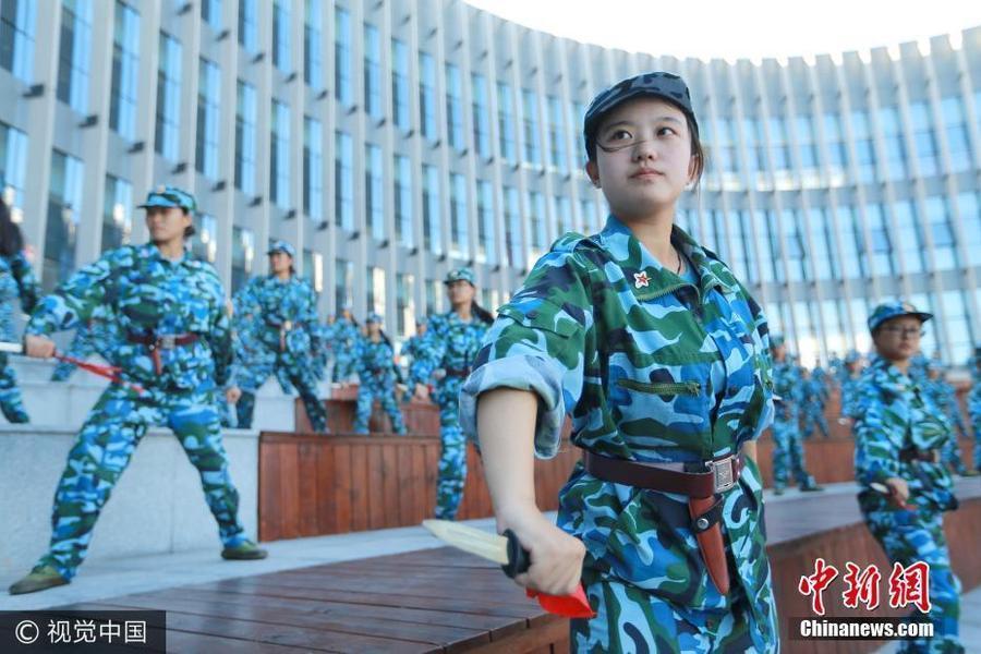 学生们手握15厘米长的橡胶制“匕首”,伴随清亮的口号,她们右脚原地用力下踏,左脚向右跨弓步后迅速转身,左臂向上划掌格挡在胸前,“哈”的一声,右手持匕首向前猛地刺出,动作整齐划一,气势如虹。