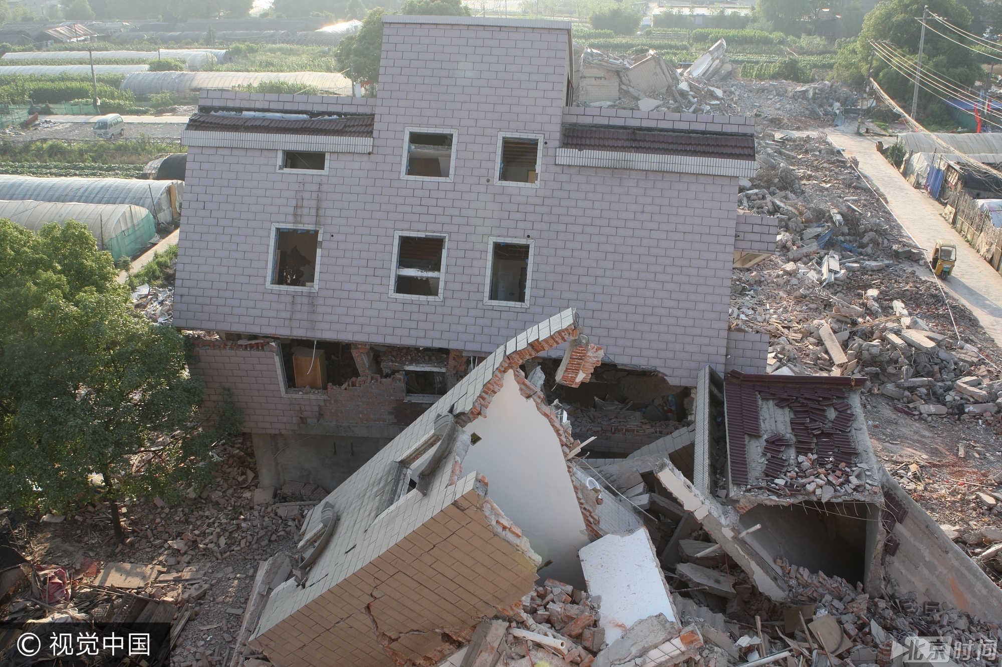 2017年5月29日，杭州一城中村拆迁工地的废墟中，一栋三层楼，一楼几乎“连根”断掉，整栋楼倾倒后，二三层楼依然完好，犹如艺术品。