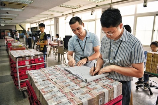 工作人员正在点钞,一推车人民币1000多万元