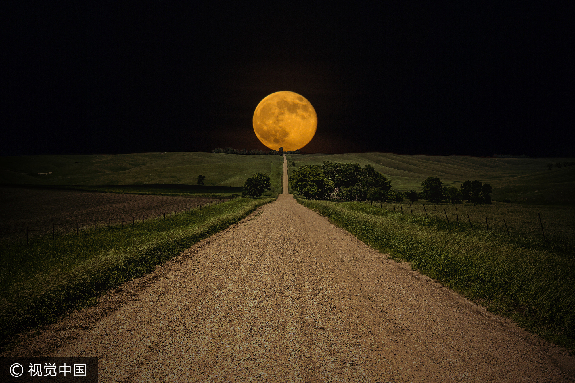 2013年10月24日消息(具体拍摄时间不详),美国南达科塔州,镜头捕捉极美的超级月亮,闪耀在夜空之中,遮蔽树木和房屋,照亮细长的小路。似乎在某一瞬间,还极为靠近一座被废弃的小木屋。