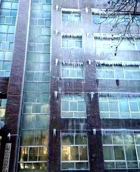 雾炮车“用力过猛” 环保局大楼被喷成冰雕