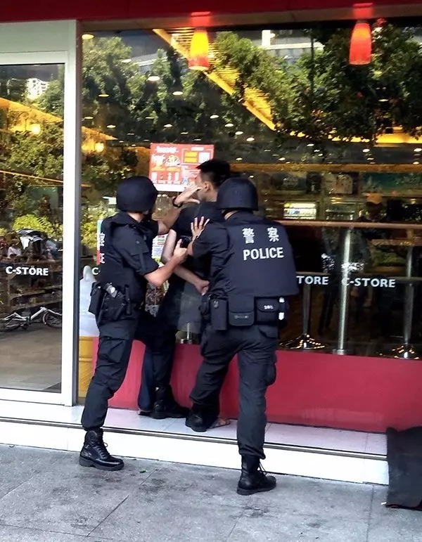 紧接着,特警队员用防暴盾牌把他顶在超市的玻璃墙面前.市民刘先生摄