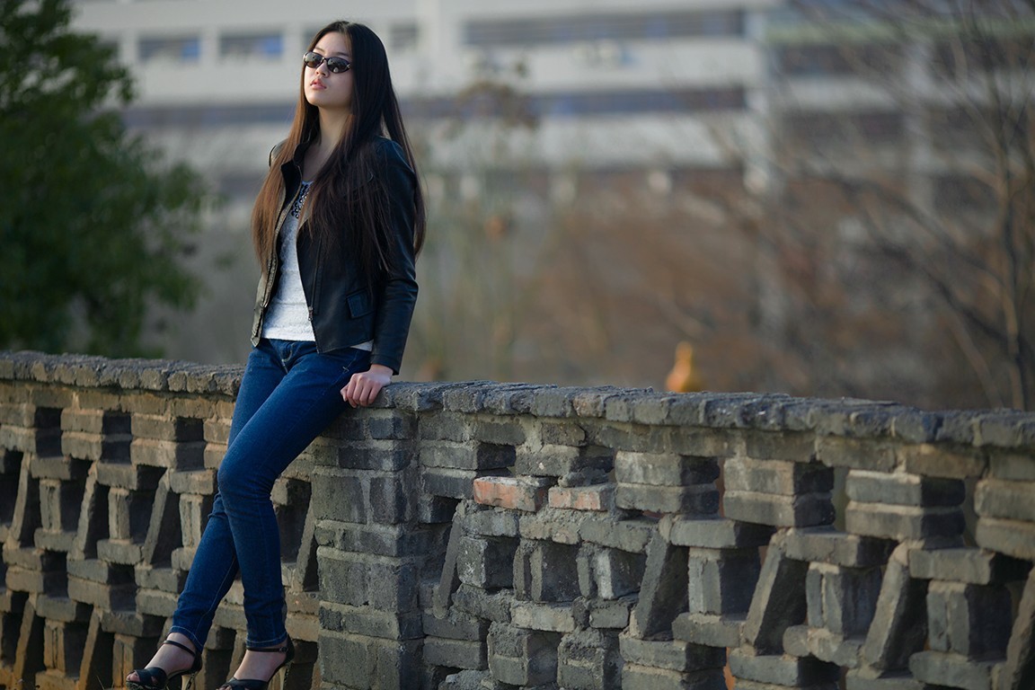 长发飘飘佩戴墨镜的姑娘在公园里显得是那么的美!