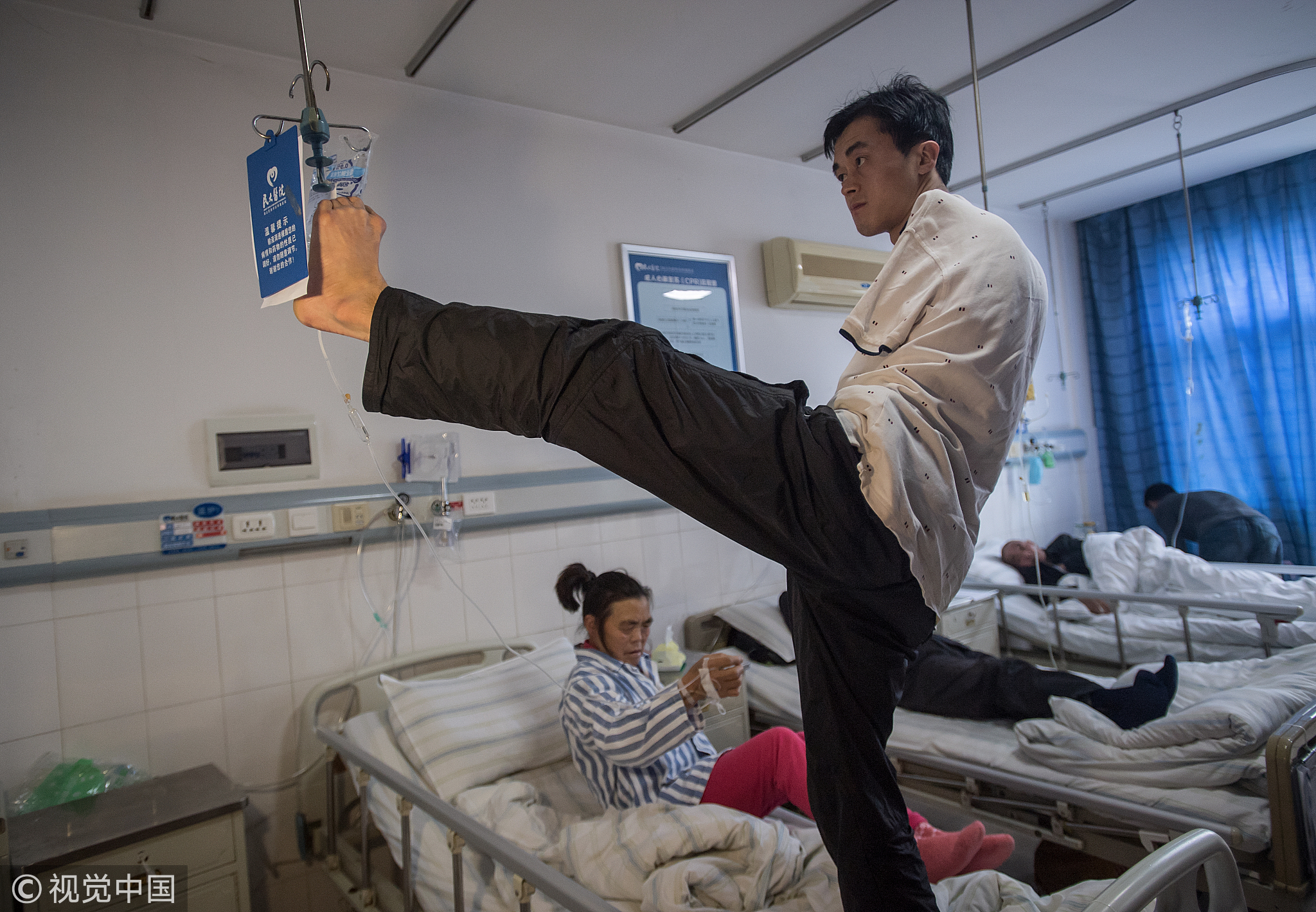 018年10月20日，湖北恩施，母亲输液时，每隔10分钟陈兹方便用脚提着药瓶陪她上卫生间。