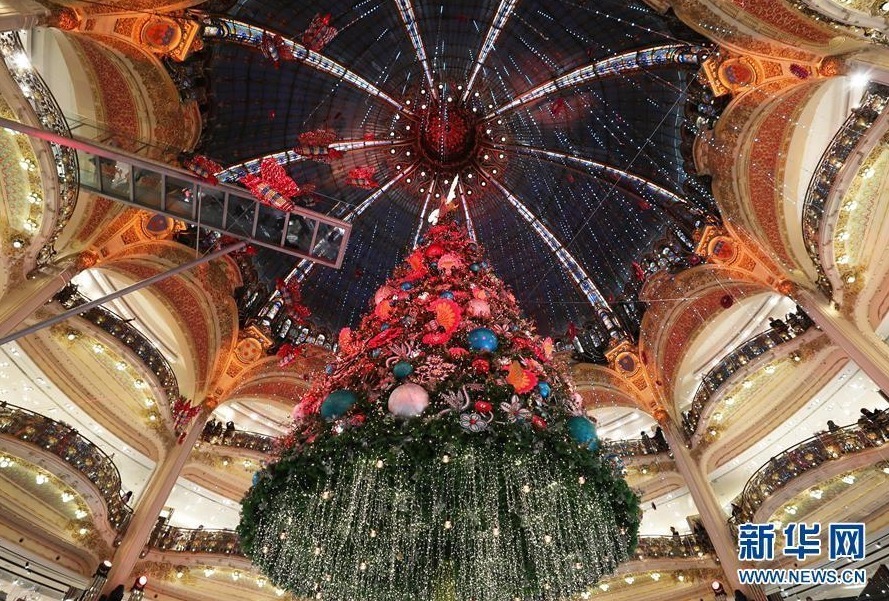  近日，法国巴黎老佛爷百货公司立起巨型圣诞树，璀璨的灯光和精美的造型设计吸引了众多市民和游客前来参观。人们还可以在商场三楼处踏上高16米、长8米的玻璃走廊，与圣诞树“亲密接触”。