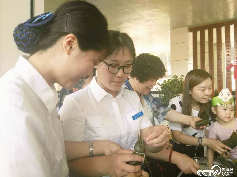 火车站将提前准备好的糯米、粽叶等食料拿到候车室桌子上,邀请旅客共同包粽子,品粽子。(摄影报道:陈静 孔令鹏)