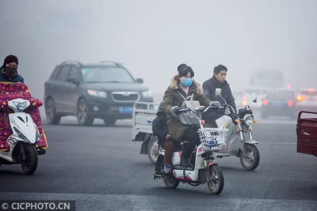 1月4日,雾霾中的洛阳街头行人.