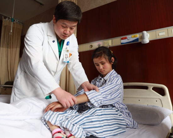 省人民医院骨科主任医师毕擎在给汪凌莹检查.