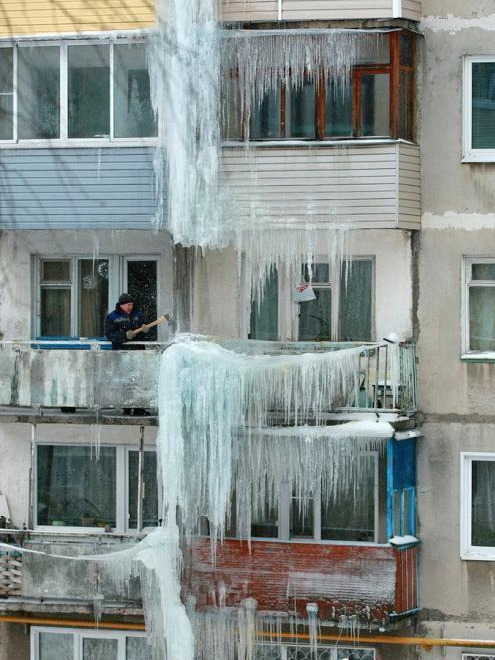 当地时间2019年2月11日，俄罗斯伊凡诺沃，当地一居民楼上挂起“冰瀑”，工作人员持大锤敲碎。