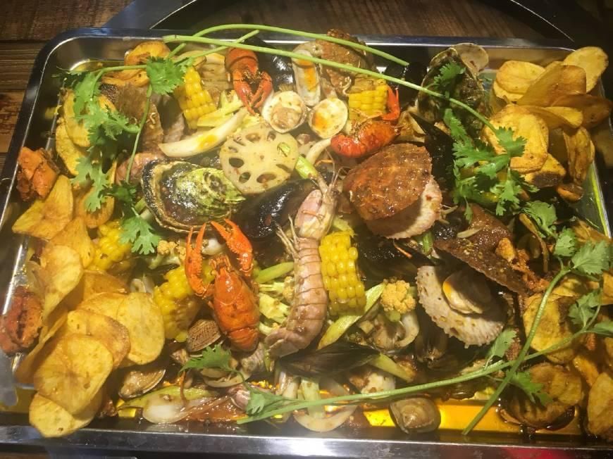 这一大盆海鲜大杂烩吃到脸都不顾,还直接用手