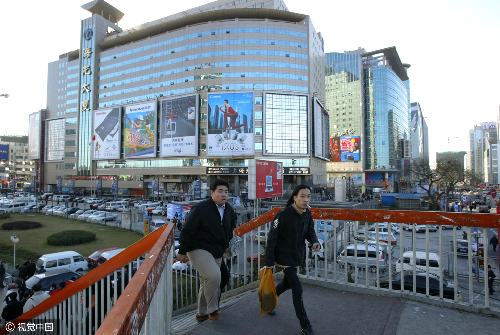 2005年，两位市民从海龙大厦外的过街天桥经过，当时这个过街天桥还是露天的，而这时的海龙大厦“脸上”已经开始长了几块广告牌，看看这些品牌你都知道么？