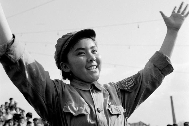 她穿着绿军装、戴军帽，胳膊上还系着毛泽东思想宣传队的红袖章，脸上带着发自内心的笑容。这是1966年10月18日，她在天安门广场跳“忠字舞”。六七十年代，全国人都穿得极其单调，“蓝灰黑”一统天下，中国女人也一样。