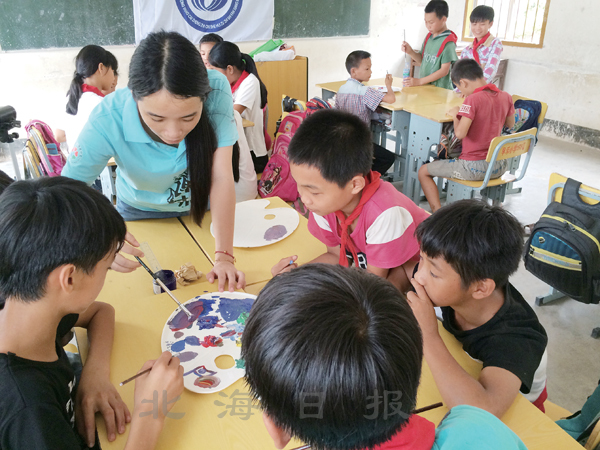 北海益众社会工作服务中心支教老师在辅导早禾小学的学生绘画.