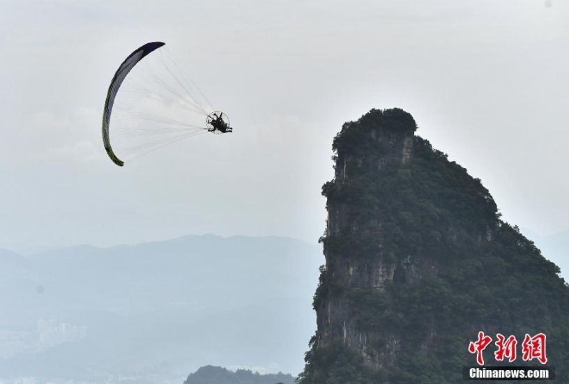6月26日，参加“极限飞荡”张家界天门山动力伞特技国际大师赛的7名选手在湖南张家界天门山景区进行首轮试飞训练，吸引了众多游客驻足观赏。“极限飞荡”张家界天门山动力伞特技国际大师赛将于6月28日至29日在张家界天门山举行。
