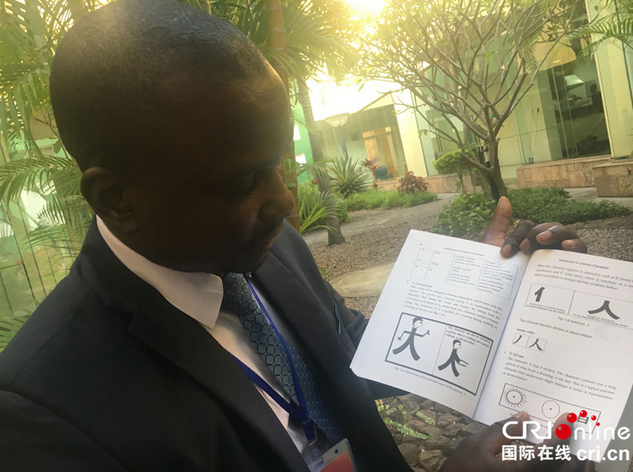 李开明展示自己编写的《汉字入门——以津巴布韦人角度学汉字》一书