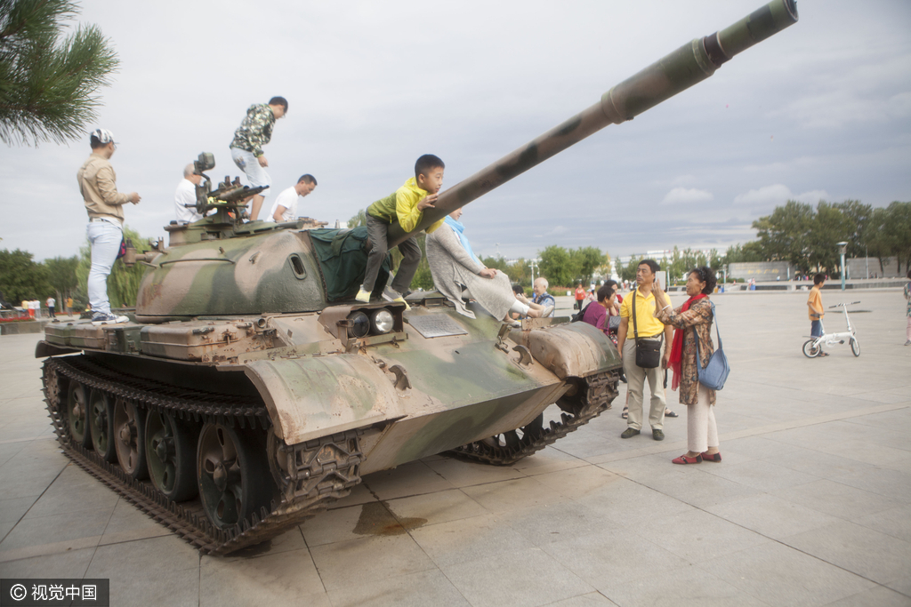 图为市民在坦克上合影。
