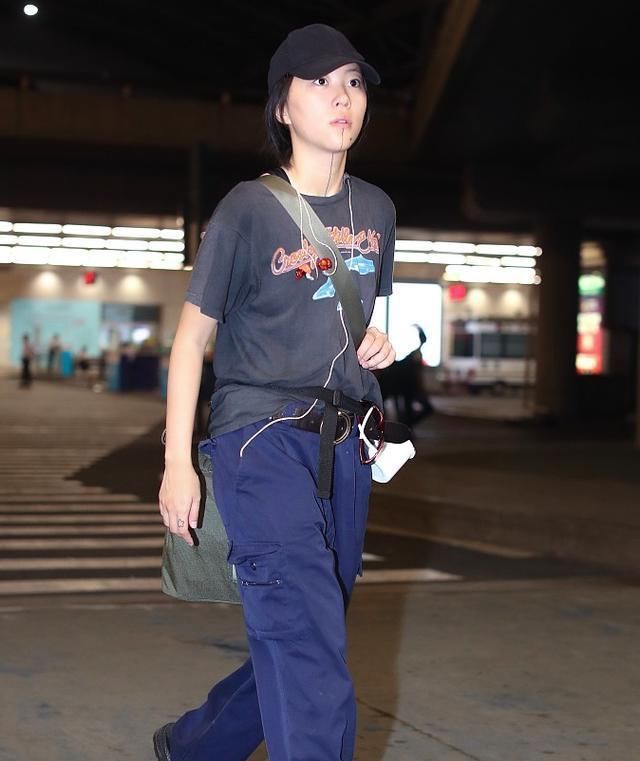 窦靖童现身机场,手臂滚字纹身吸睛,腰间搪瓷