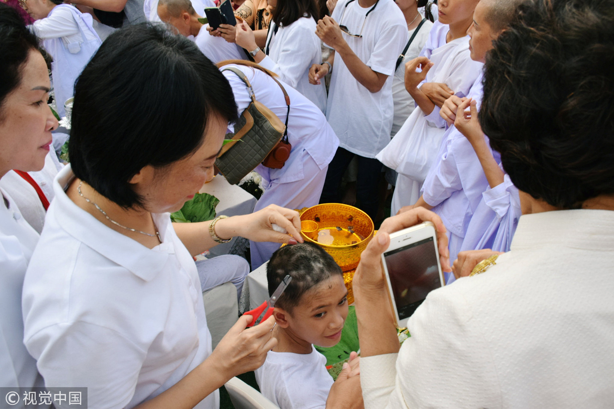 当地时间2018年7月24日，泰国清莱府，泰国“野猪”少年足球队中的12名成员参加剃度仪式。他们将在25日正式出家，为期9天，足球队员中有一人因基督教未出家。