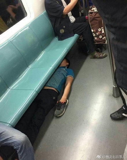 北京地铁一男子竟脱鞋躺在座椅下