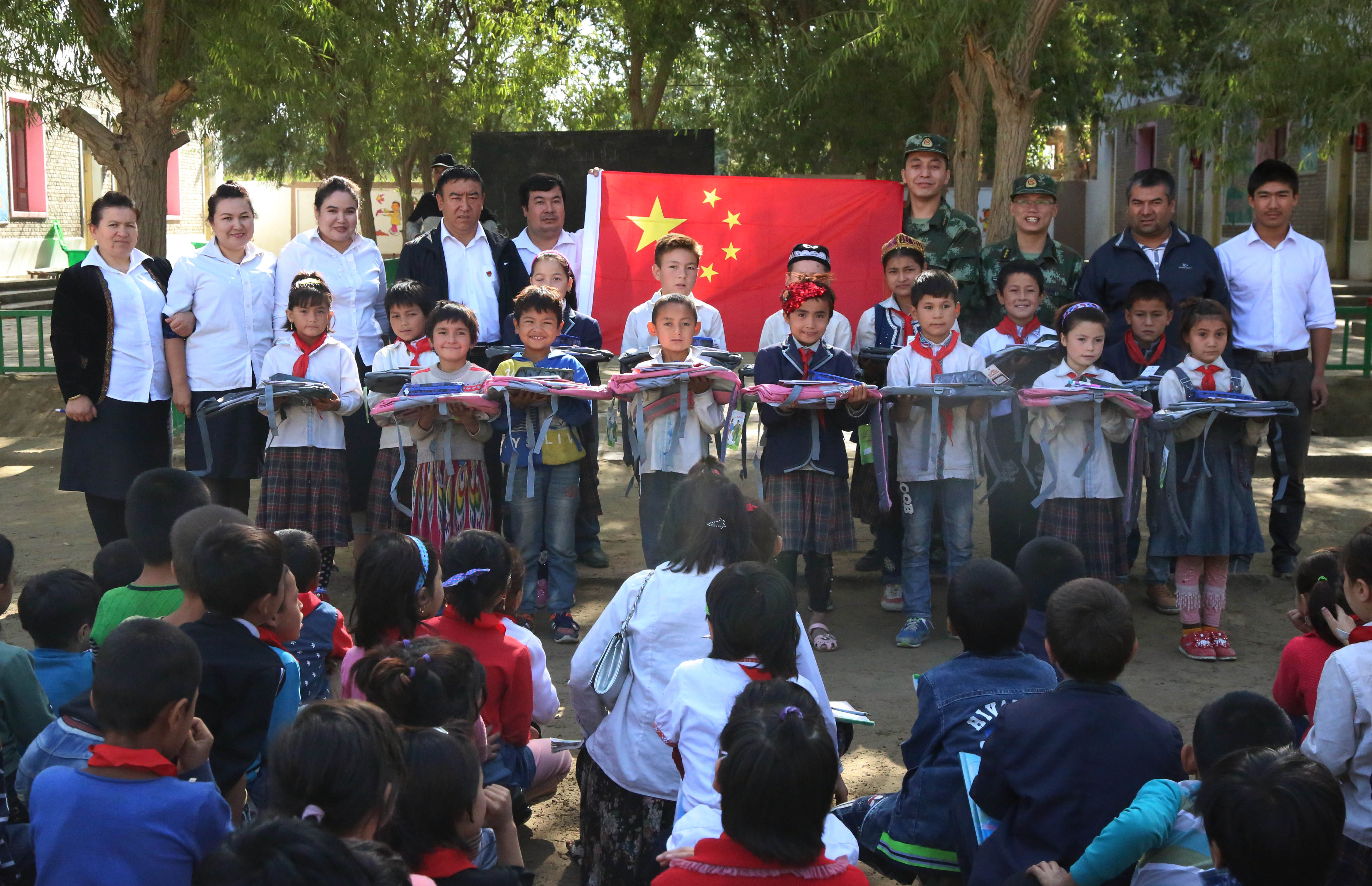 武警新疆总队官兵为驻地贫困学生捐赠学习用品。张银博摄